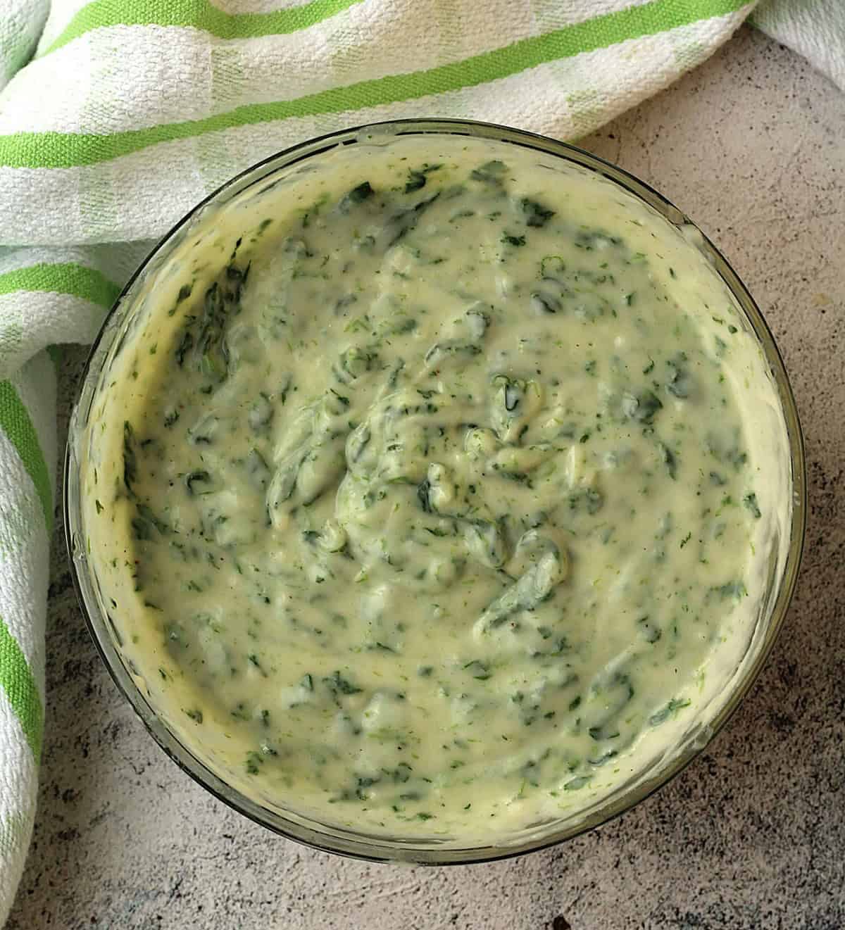Béchamel sauce with spinach stirred in in glass bowl,