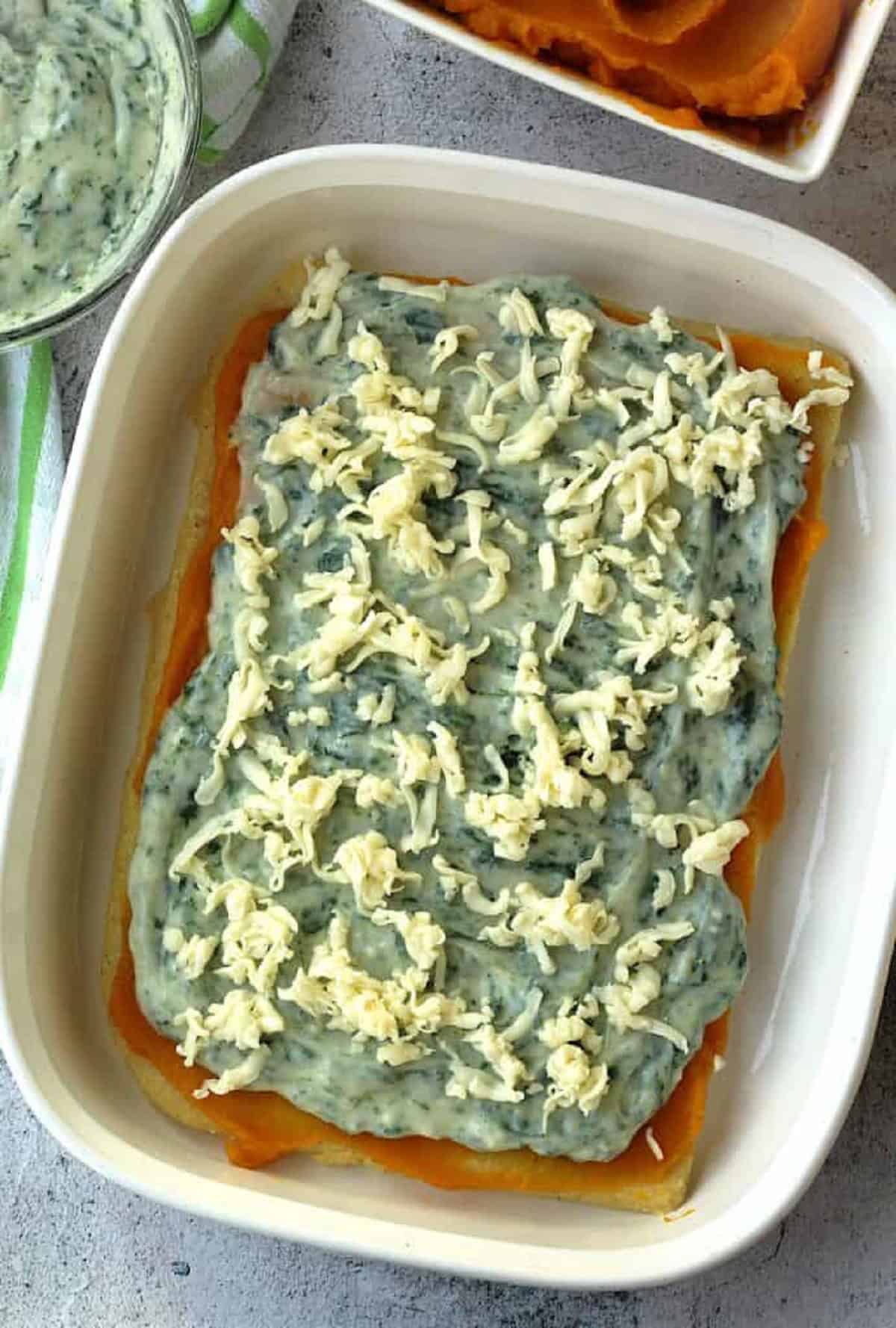 Spinach béchamel sauce and mozzarella spread over polenta sheet.