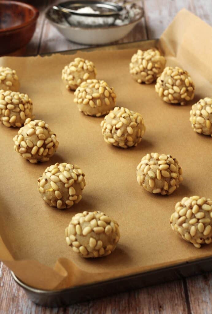 Raw pignoli cookies (pine nut cookies) on baking sheet.