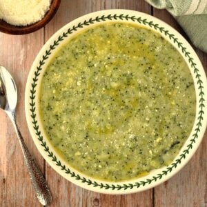 Bowl with polenta and broccoli (frascatula) with spoon on side.