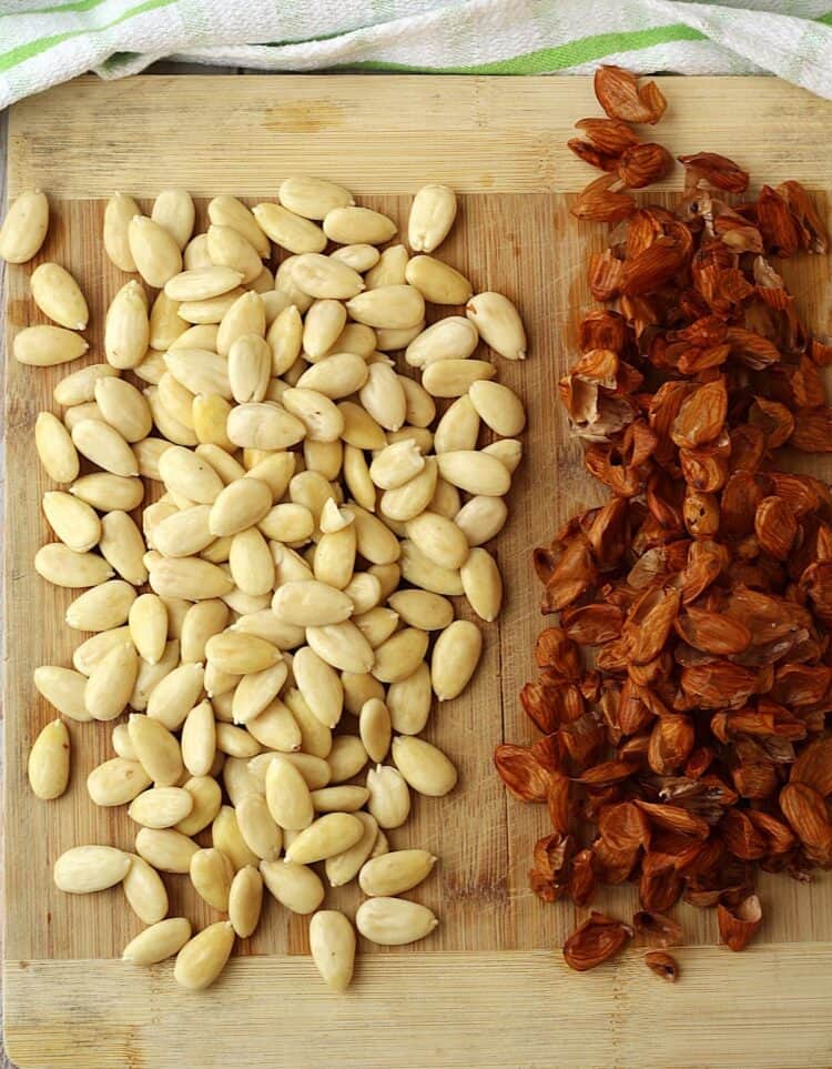 Skinned almonds on wood board.