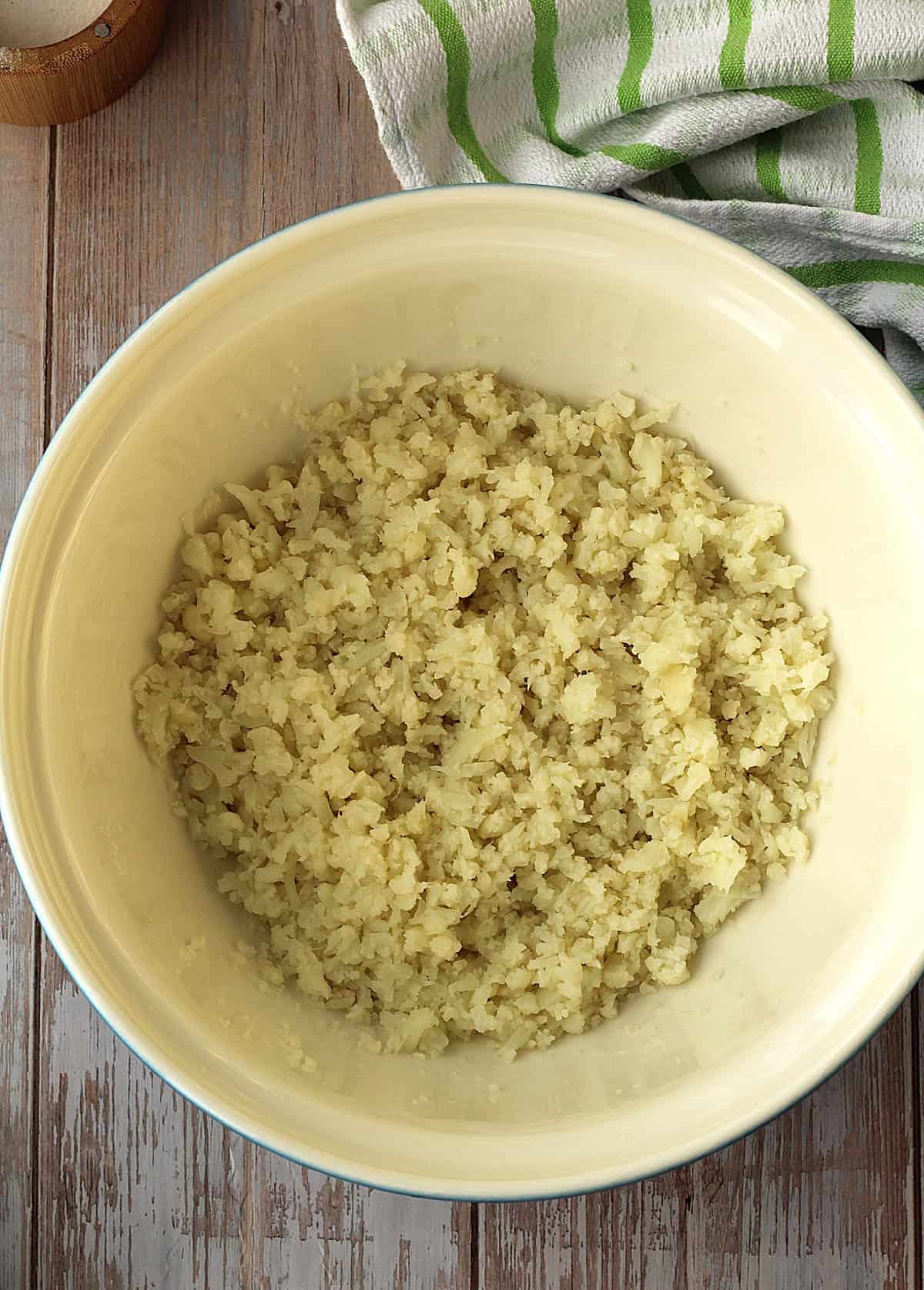 Mashed cauliflower in large bowl for meatball recipe.