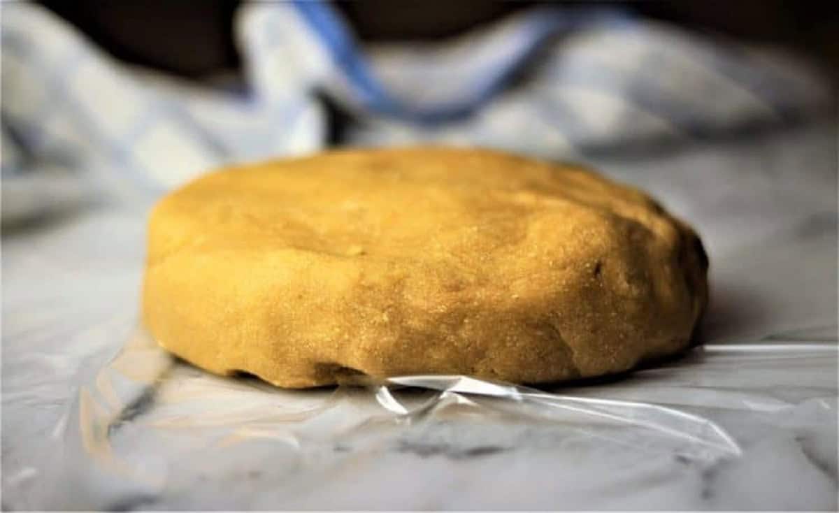 Chickpea flour pasta dough shaped into a disc.