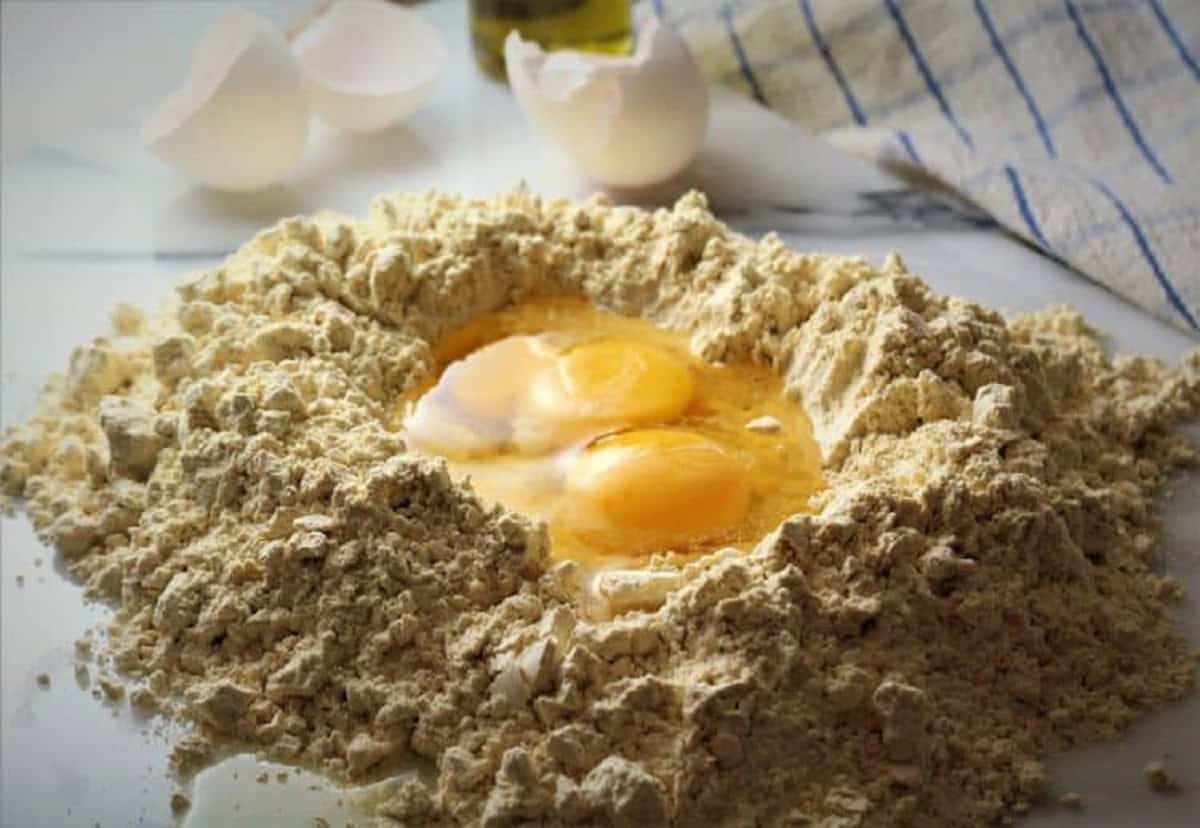 Chickpea flour mounded with eggs in the center for making pasta.