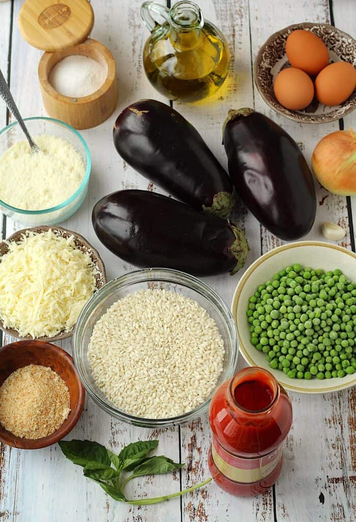 Eggplant, rice, peas, tomato sauce, basil, breadcrumbs, cheese, salt, oil, eggs, onion and garlic.