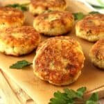 Sicilian cauliflower meatballs on wood board with parsley leaves.