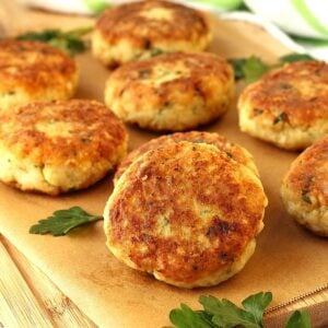 Sicilian cauliflower meatballs on wood board with parsley leaves.