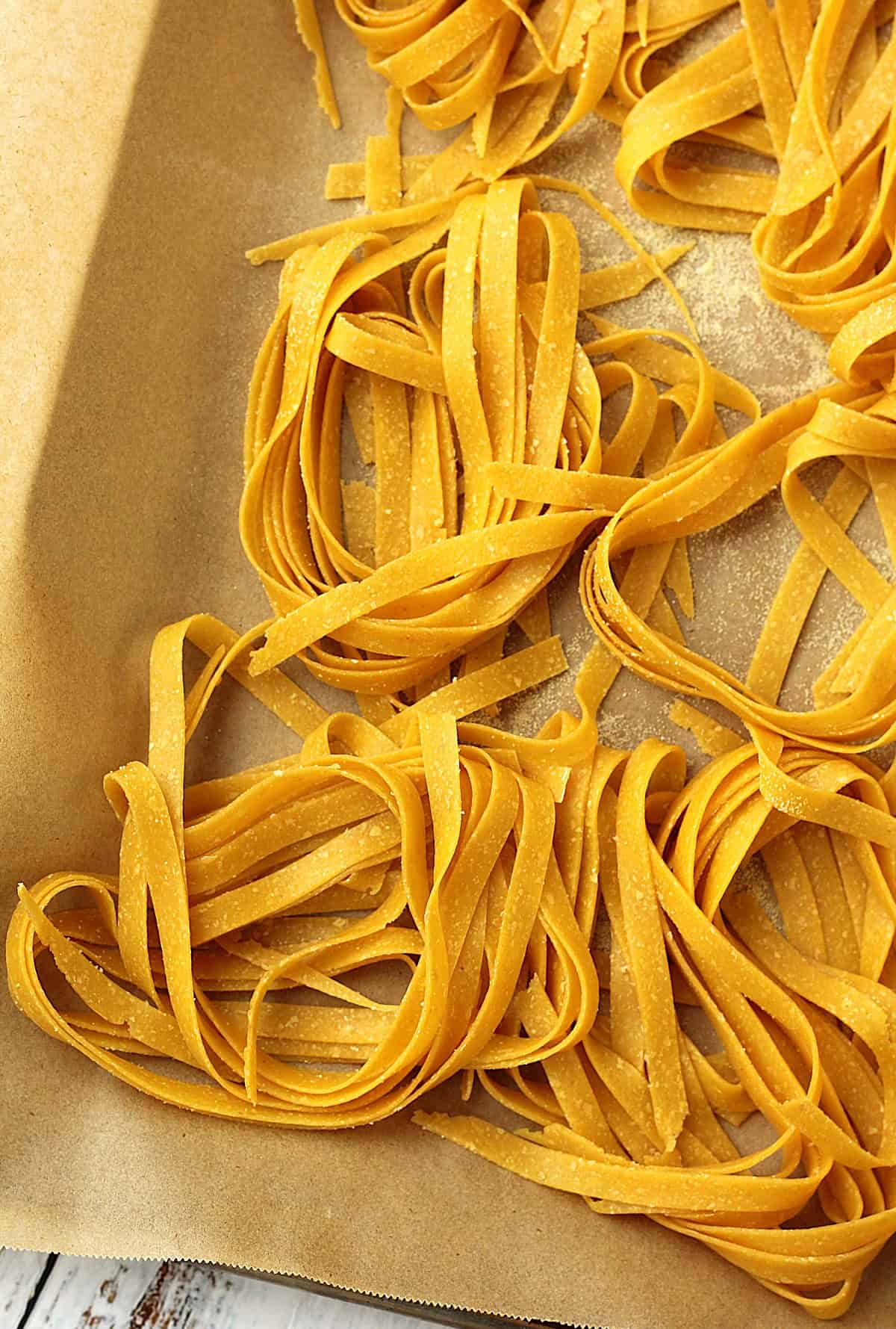 Chickpea flour tagliatelle nests on parchment paper.