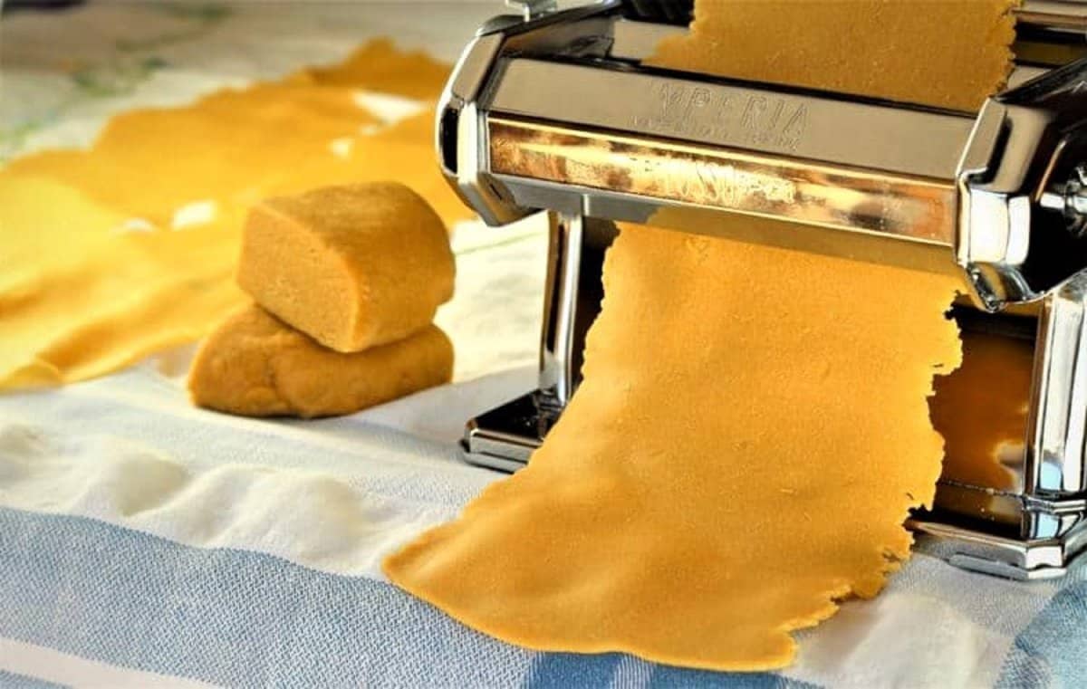 Chickpea flour pasta sheets rolled in pasta machine.