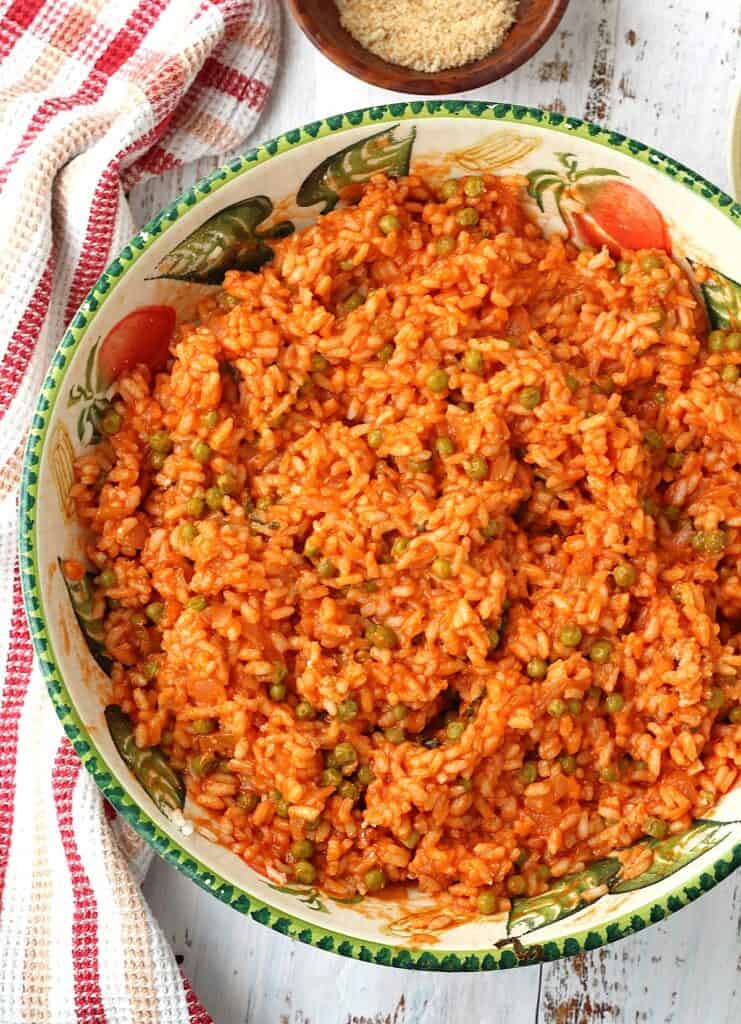 Rice with tomato sauce and peas in large bowl.