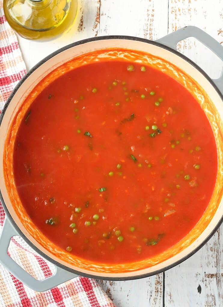 Tomato sauce with peas in large skillet.