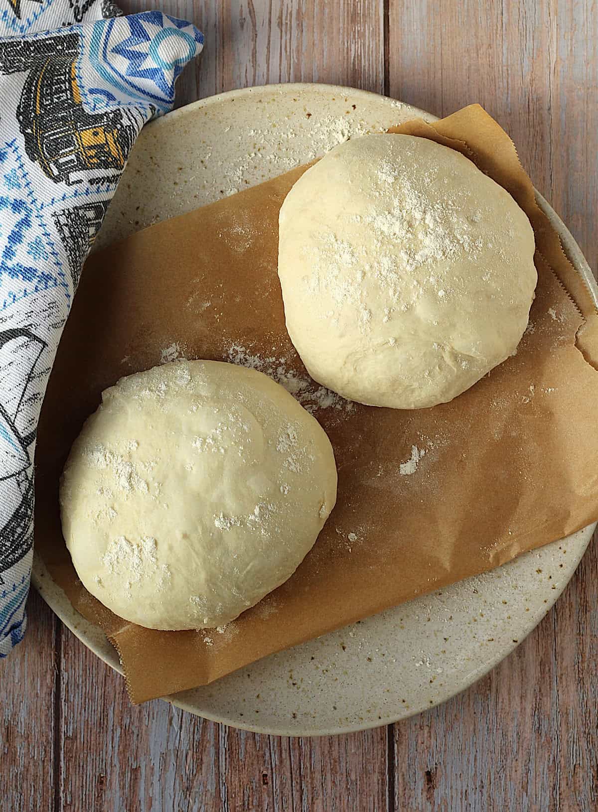 Two pizza dough balls on plate for scacciata.