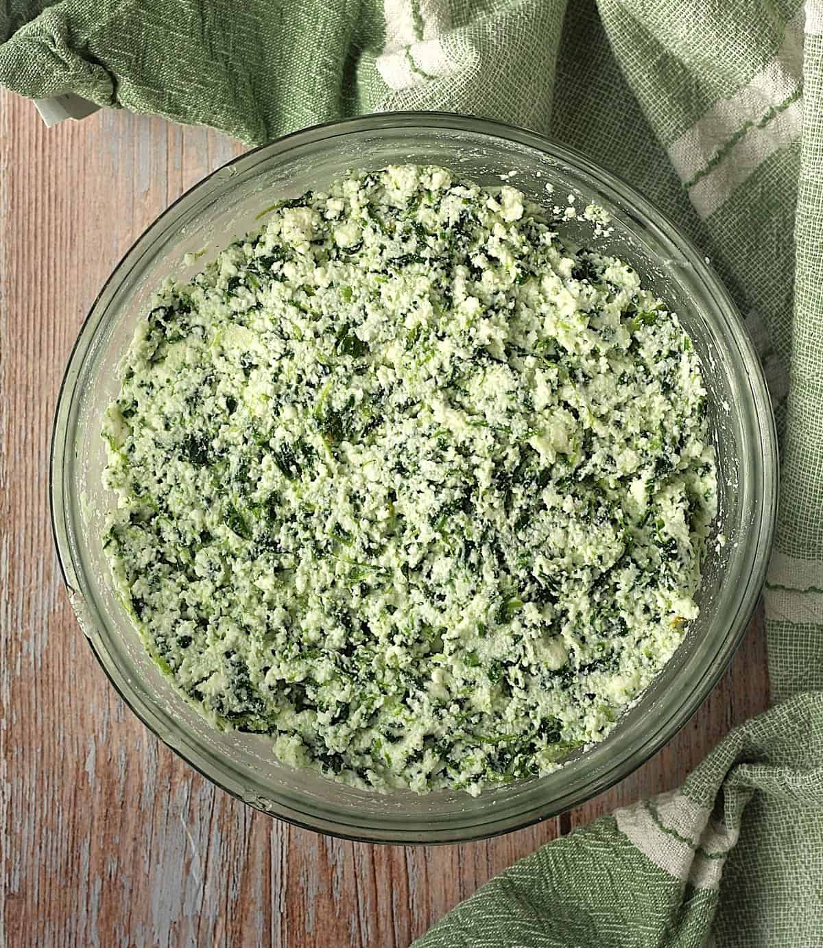 Bowl with spinach, ricotta filling for scacciata recipe.