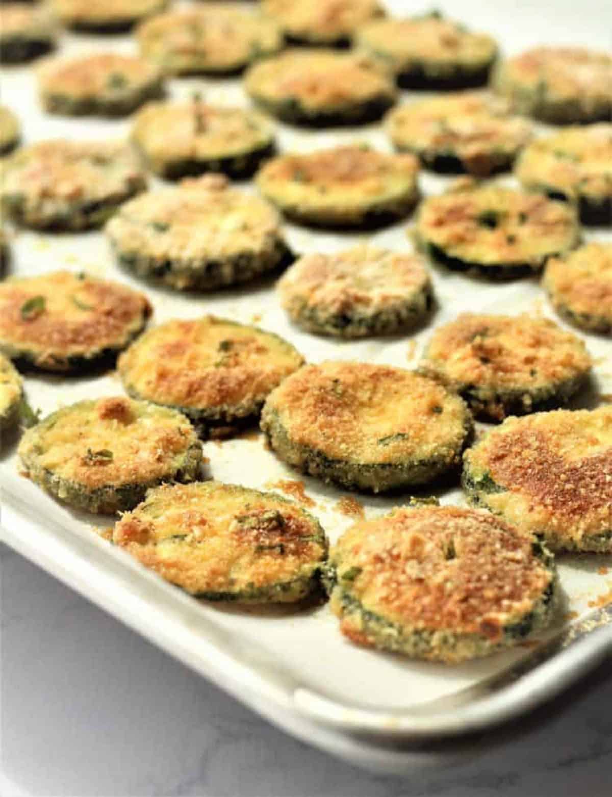 Baked parmesan zucchini crisps on baking sheet just out of the oven.