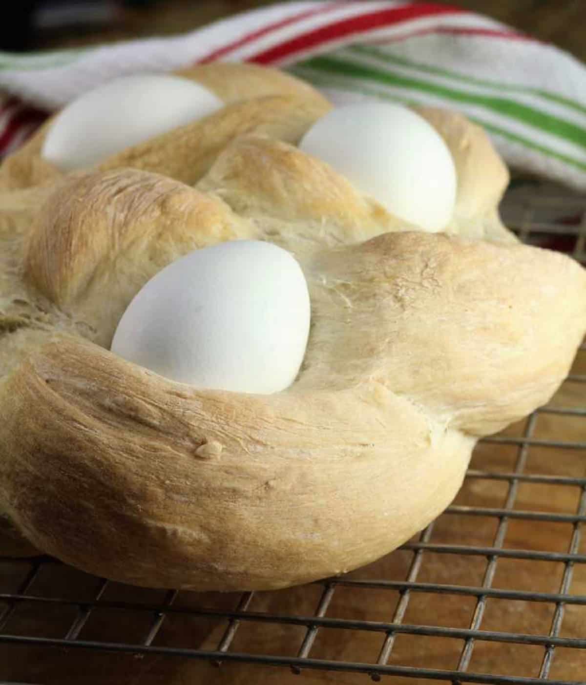 Sicilian Easter Bread (cuddura cu l'ova) Sicilian Easter bread with eggs (cuddura cu l'ova) on cooling rack.