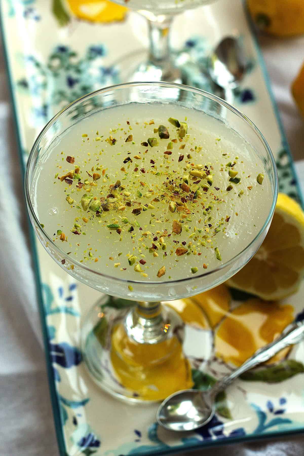 Sicilian gelo di limone topped with pistachio garnish in stem glass.