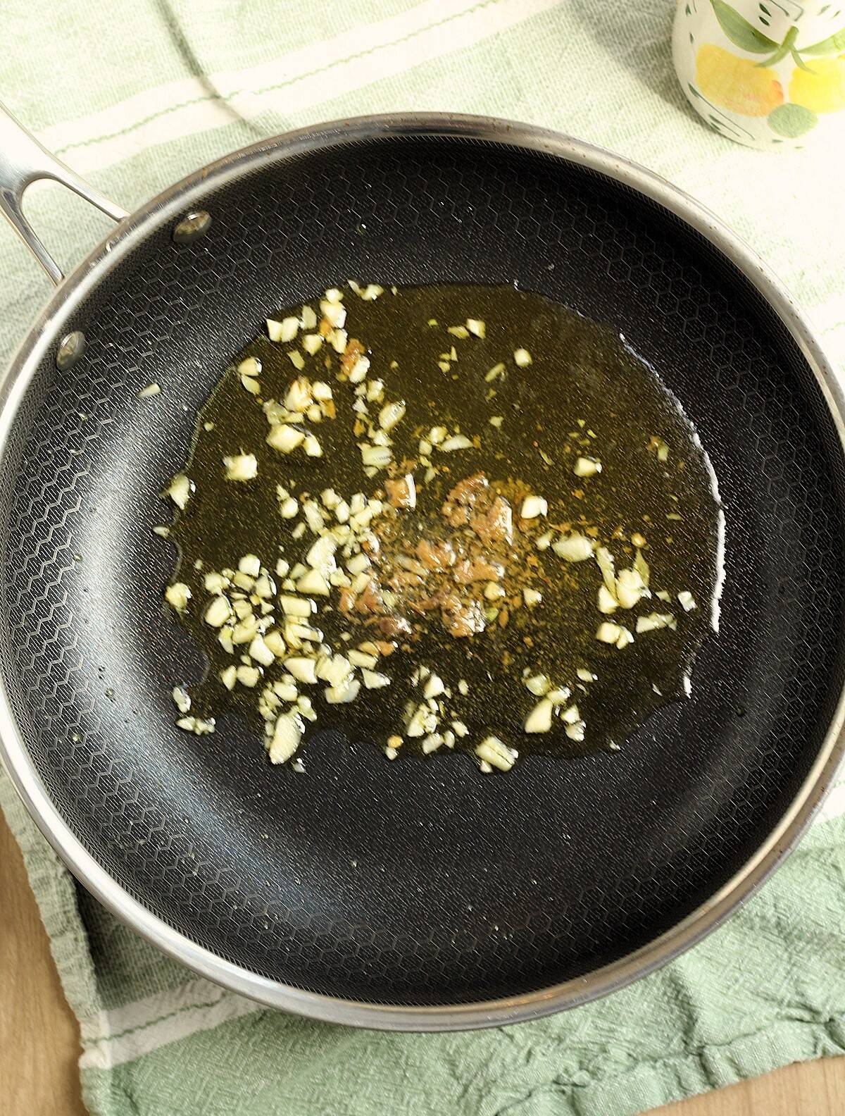 Sautéed garlic and anchovy filet in olive oil in skillet.