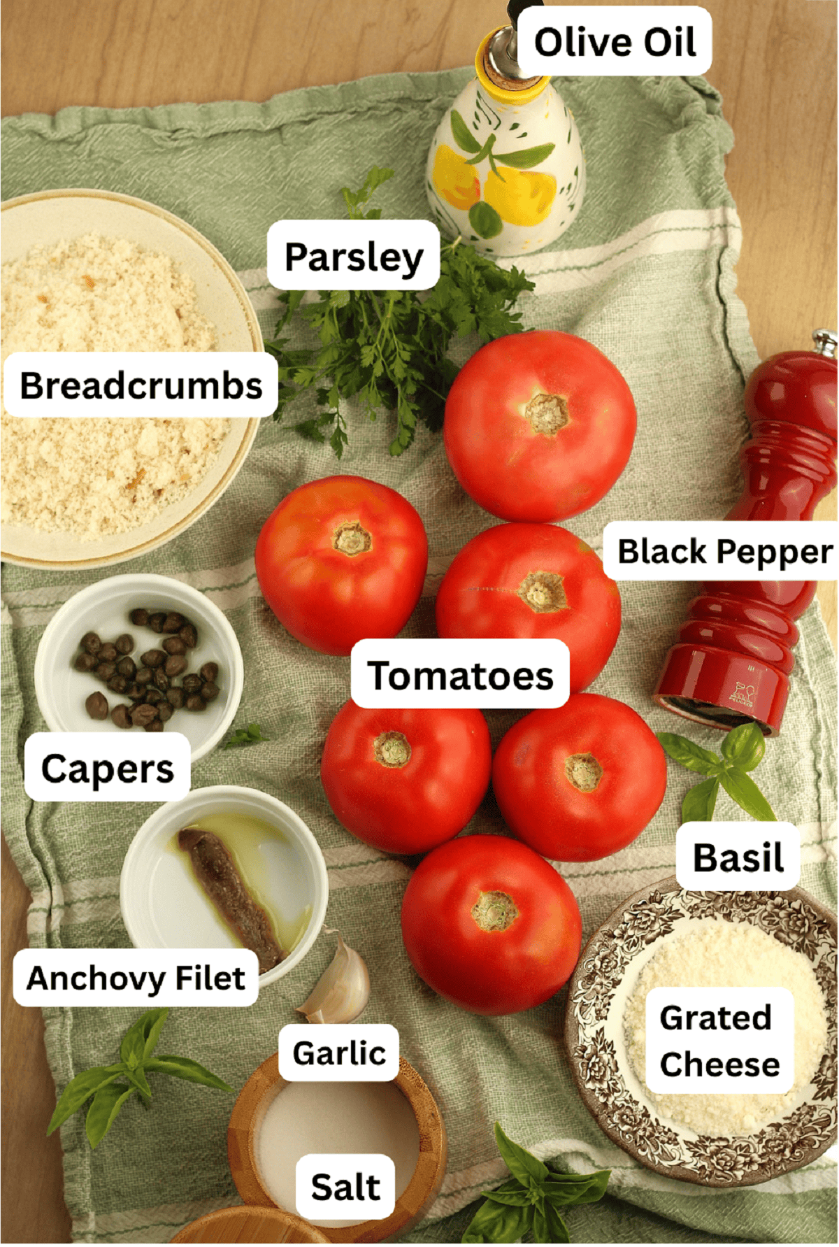 Tomatoes, breadcrumbs, cheese, salt, oil, basil, parsley, anchovy, capers and garlic for stuffed tomato recipe.