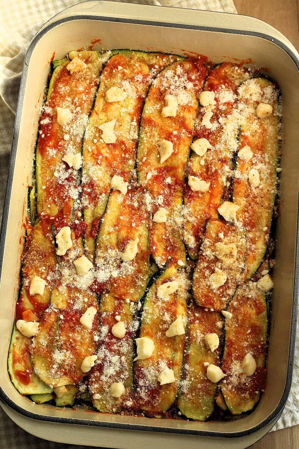 Baked zucchini parmigiana in casserole dish.