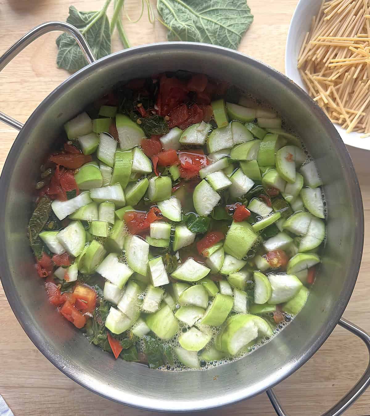 Diced cucuzza and tenerumi simmering in sauce pan.