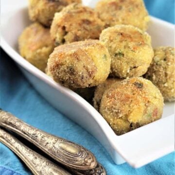 Breaded baked eggplant meatballs piled on plate.