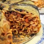 Anelletti al forno with eggplant on plate with wedge cut out.