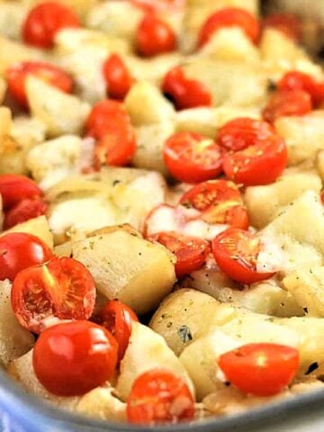 Sicilian patate vastase with tomatoes and mozzarella in casserole dish.