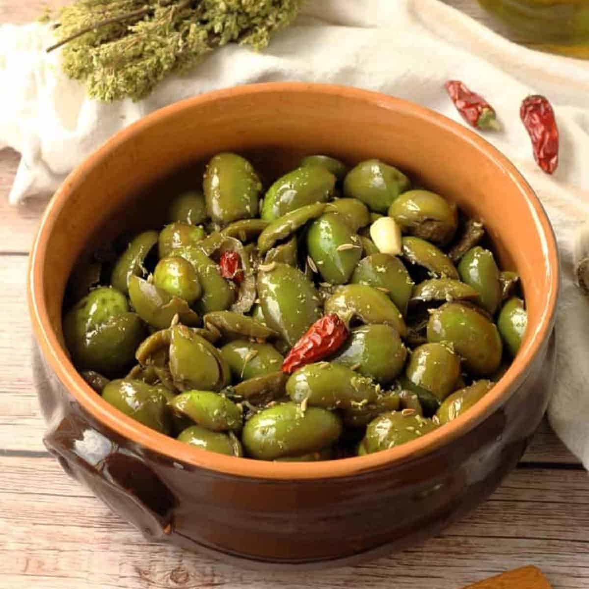 Sicilian seasoned cracked green olives in bowl.