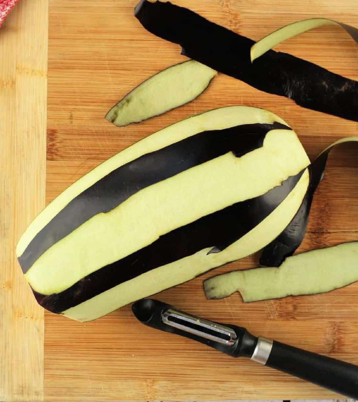 Globe eggplant peel removed in strips with vegetable peeler for eggplant meatballs.