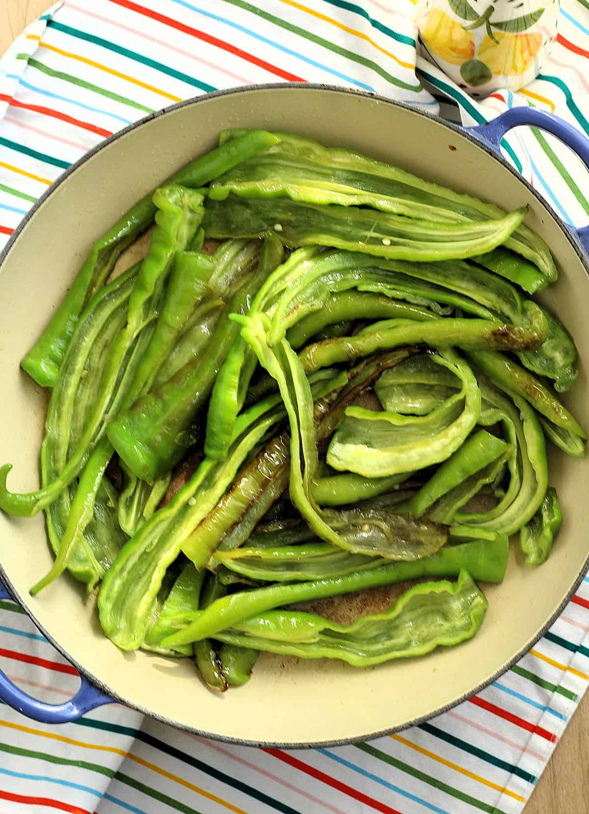 Pan-fried Italian long sweet peppers in skillet.