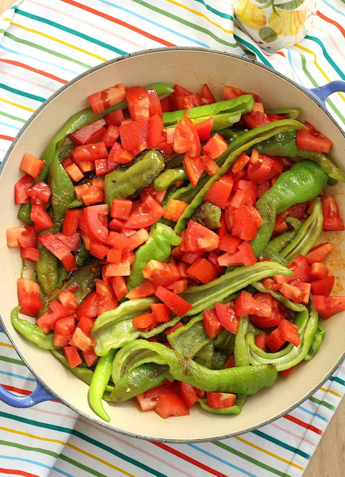 Fried peppers with tomatoes in large skillet.