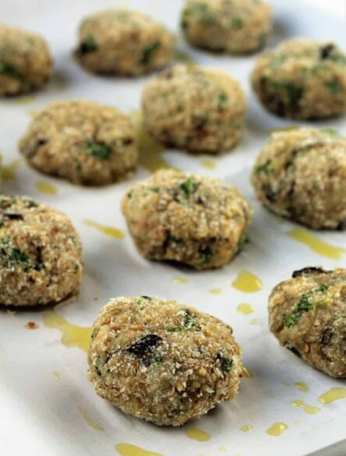 Baked eggplant meatballs on baking sheet.