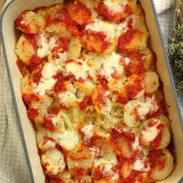 Roasted potatoes alla pizzaiola in casserole dish.