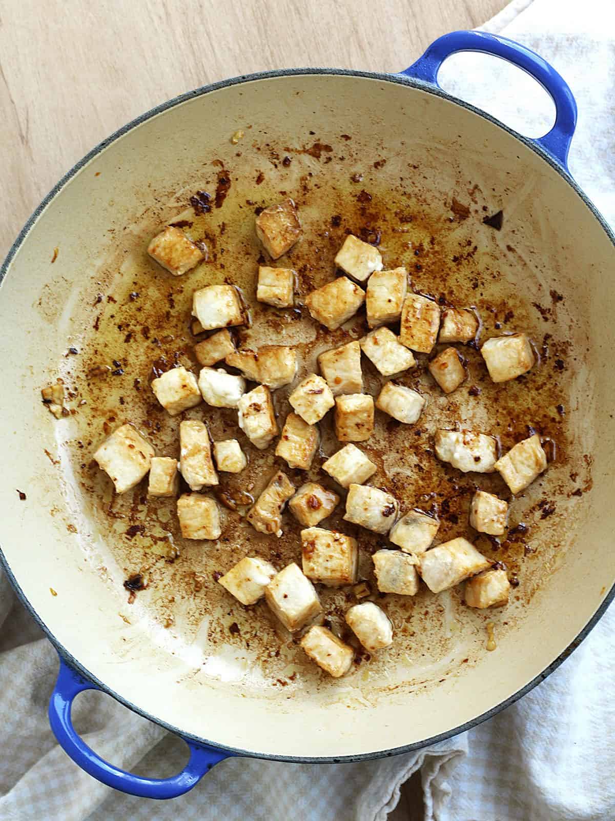 Cubed swordfish sautéed in skillet with garlic.