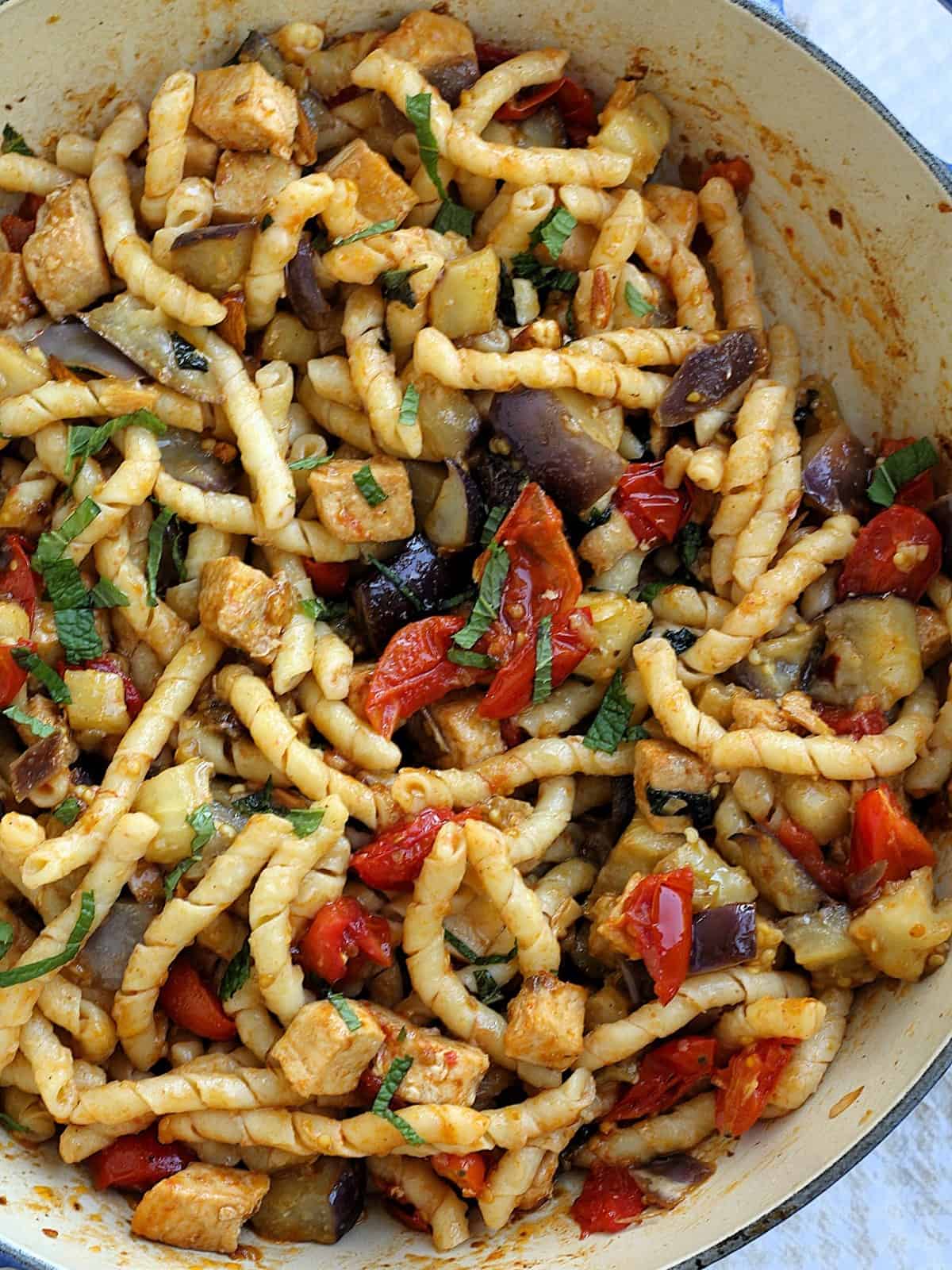 Pasta with eggplant, swordfish, tomatoes and mint in large skillet.