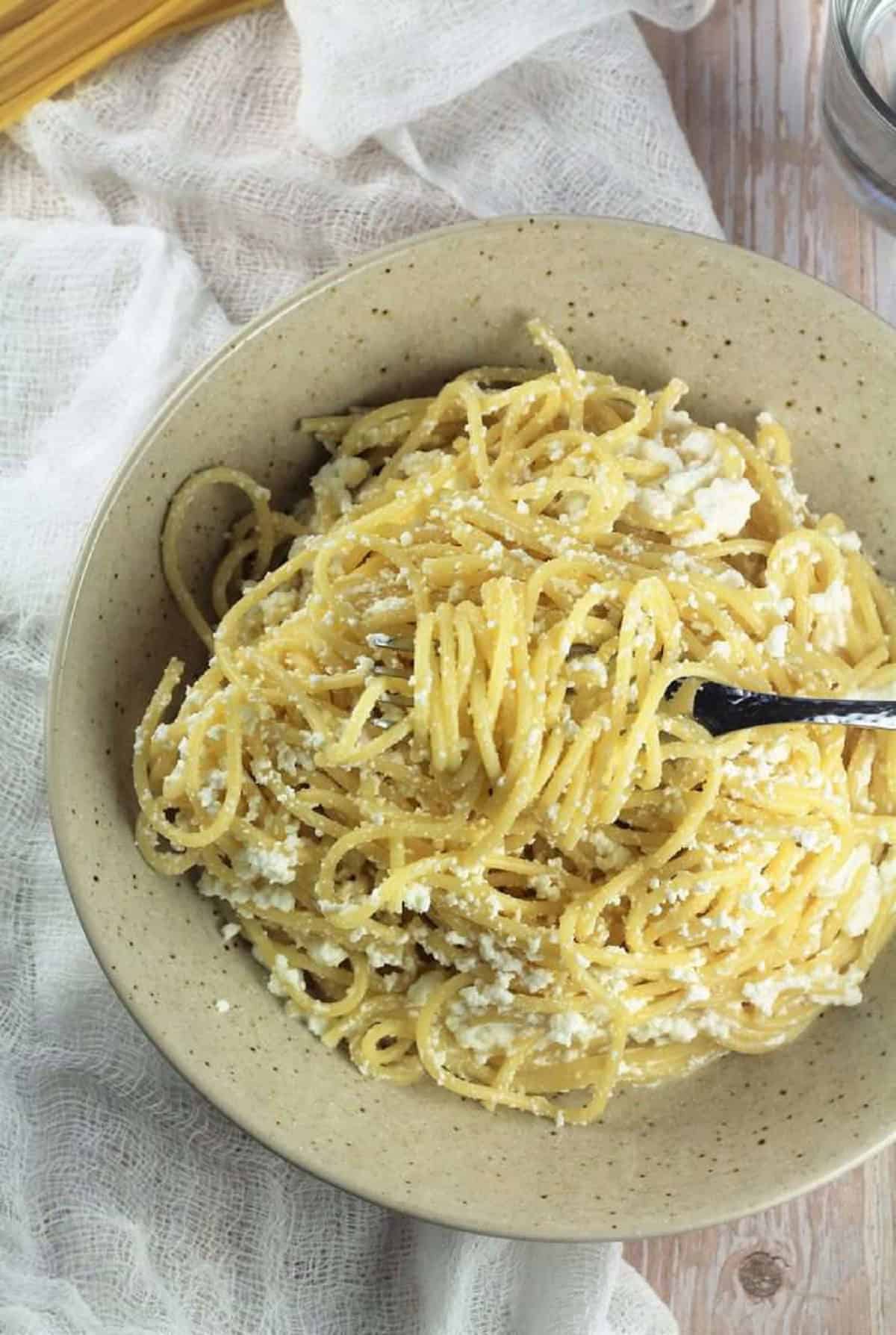 Ricotta pasta in bowl twirled with fork.