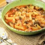 Broccoli potato soup with pasta in green bowl.