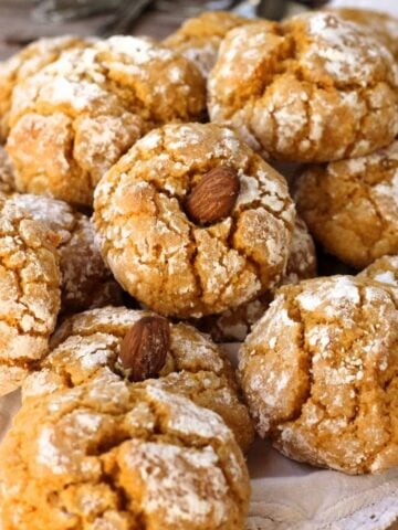 Pumpkin almond flour cookies topped with almond piled on plate.