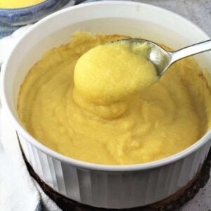 Creamy oven baked polenta spooned in white casserole dish.