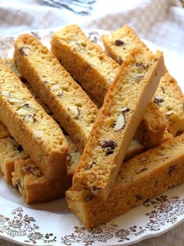 Easy sheet pan almond biscotti piled on plate.