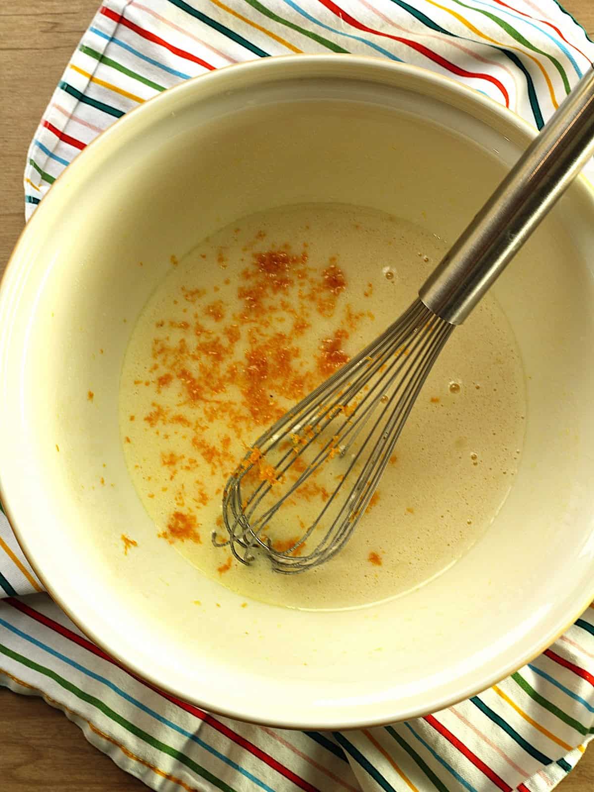 Eggs, oil and sugar whisked with orange zest stirred in.