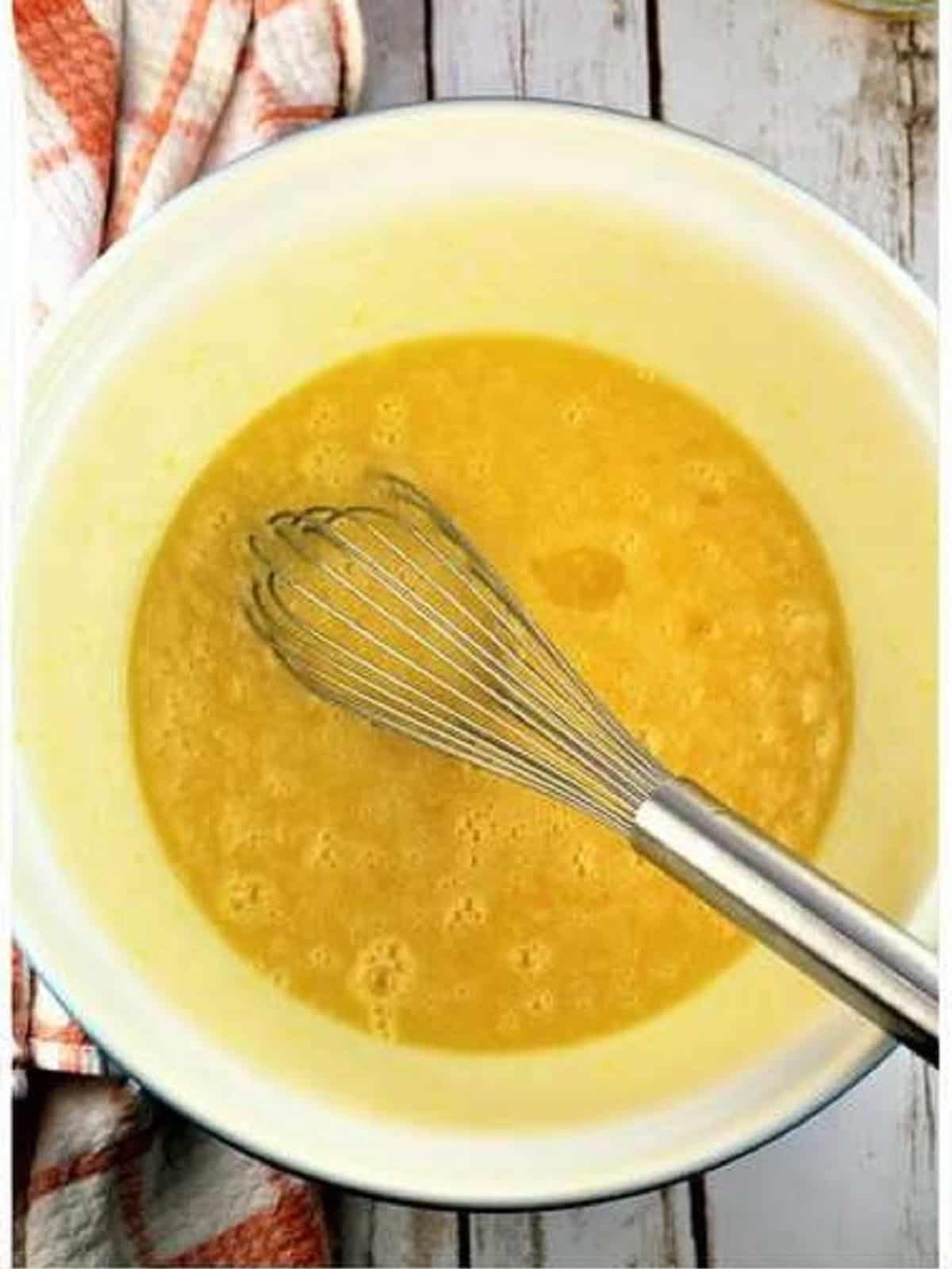 Eggs, oil and sugar whisked in large bowl for sheet pan almond biscotti recipe.