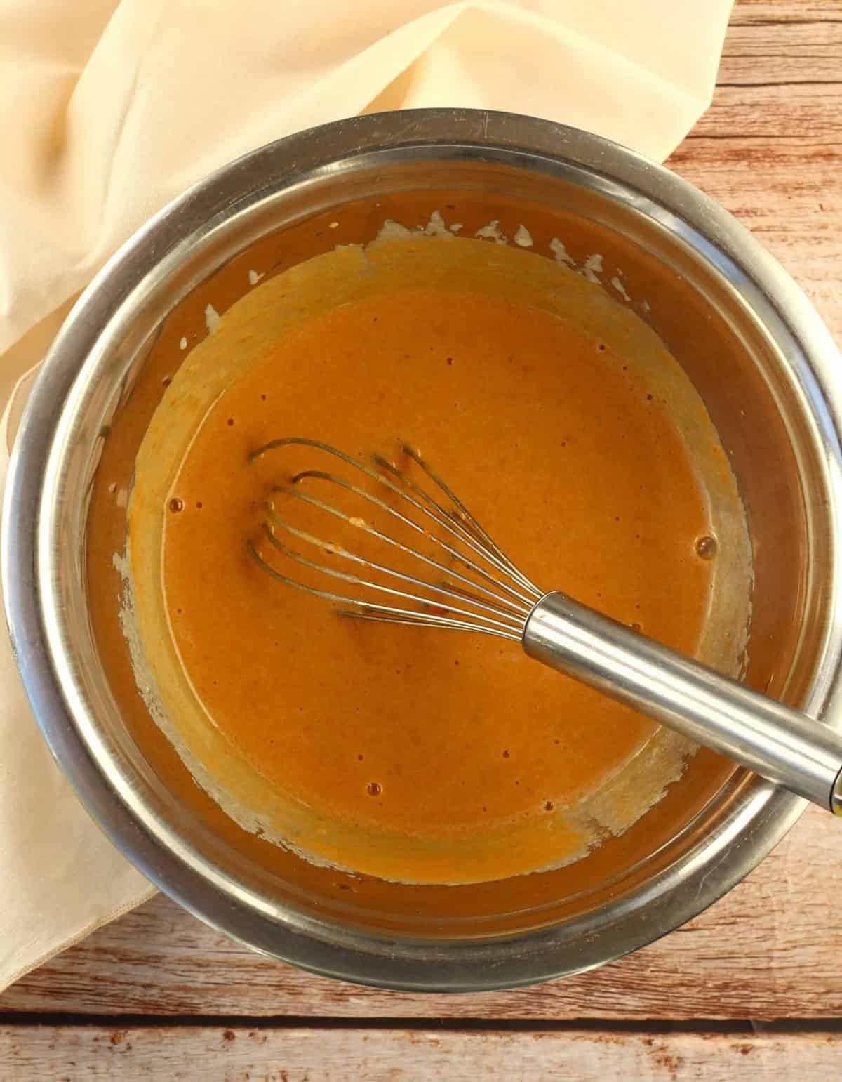 Pumpkin purée whisked in bowl with oil, sugar and egg.