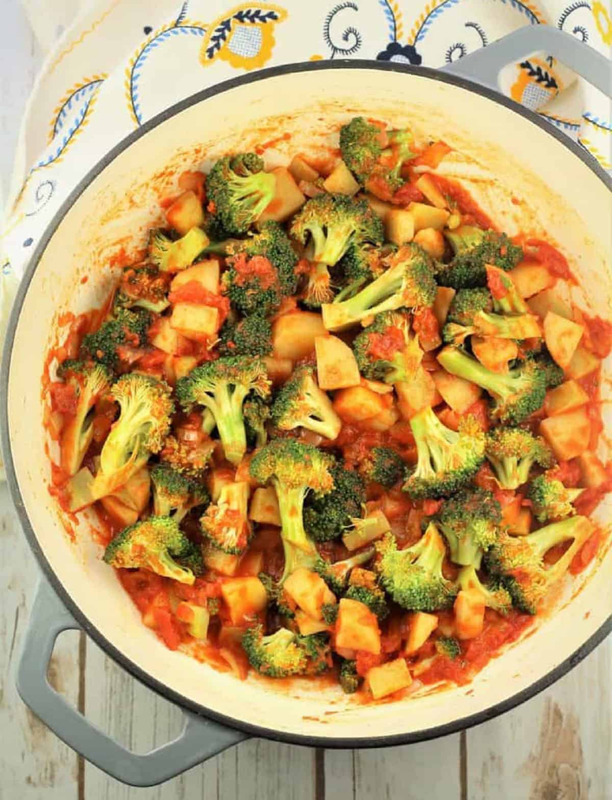 Broccoli, diced tomatoes, onions and potatoes in skillet.