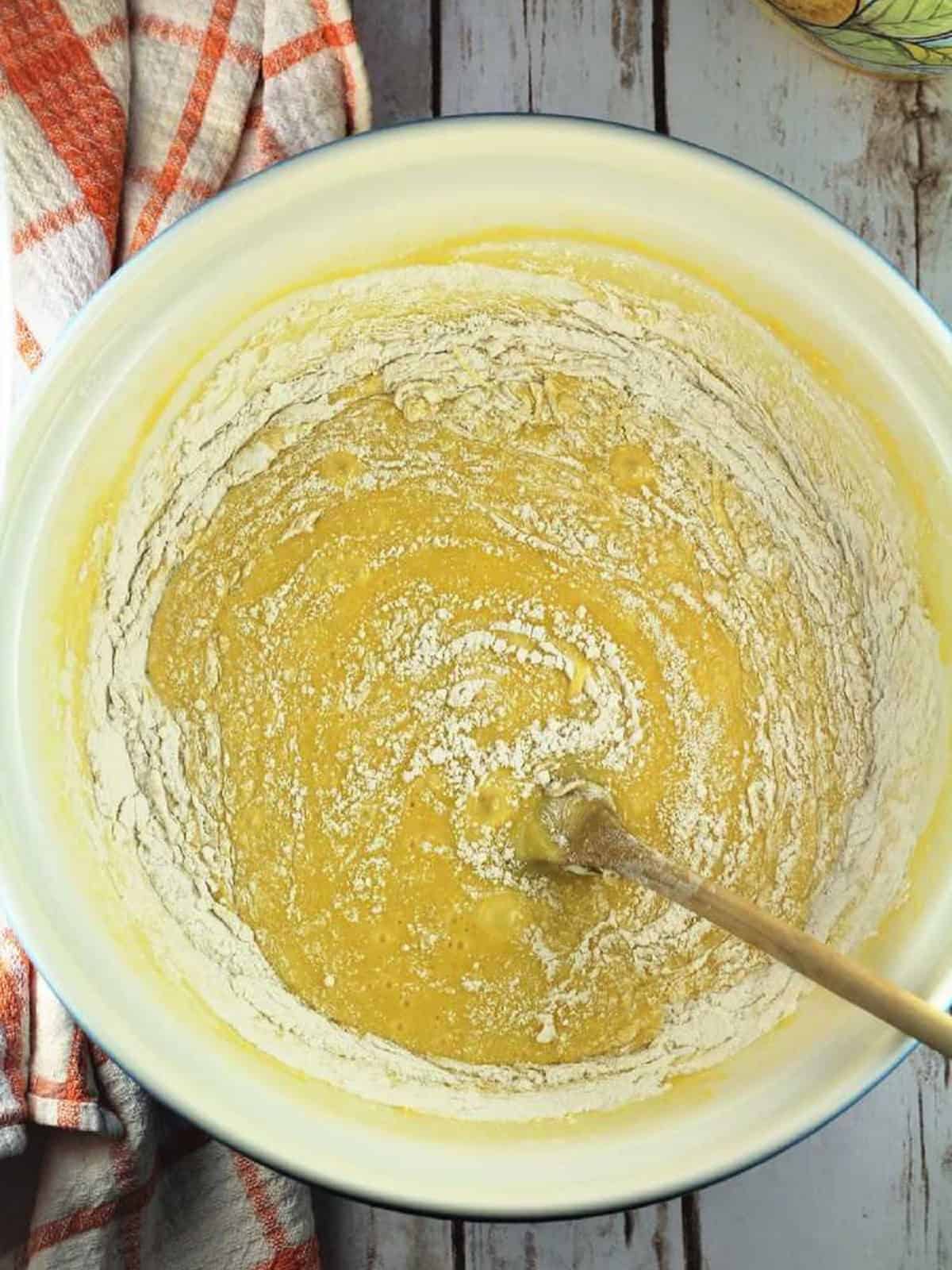Sheet pan biscotti batter with flour whisked in bowl.