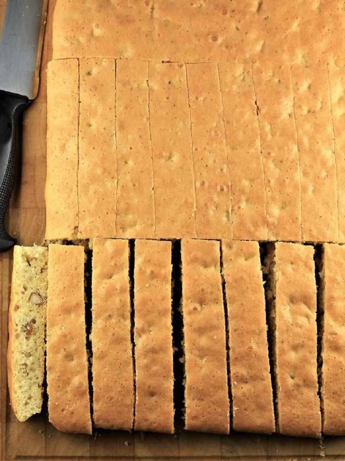 Sliced sheet pan biscotti on wood board.