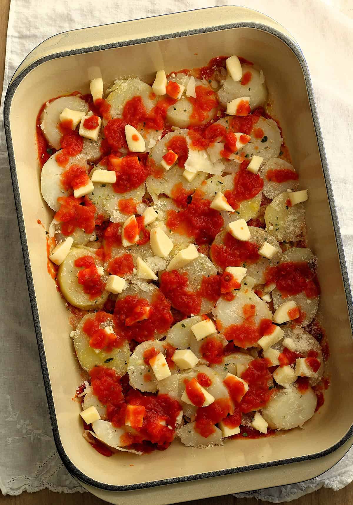 Sliced potatoes topped with tomato sauce and mozzarella cheese.