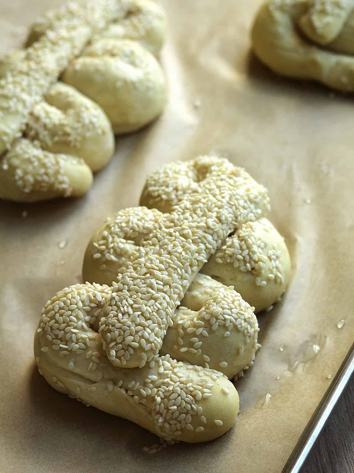 Mafalda bread dough topped with sesame seeds on baking sheet.