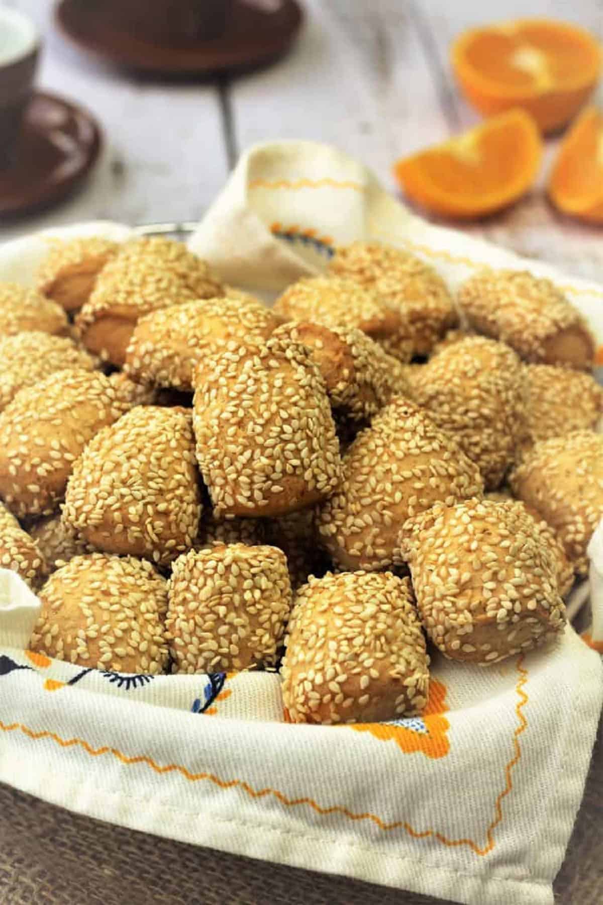 Sicilian sesame seed cookies (reginelle) piled on dishcloth covered basket.