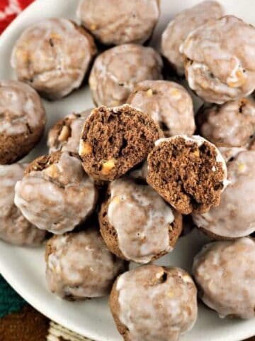 Sicilian chocolate spice cookies piled on plate with one cut open.